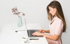Mujer escribiendo en un ordenador portátil