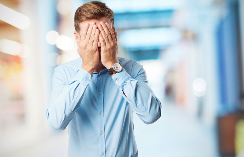 Hombre tapándose la cara con las manos