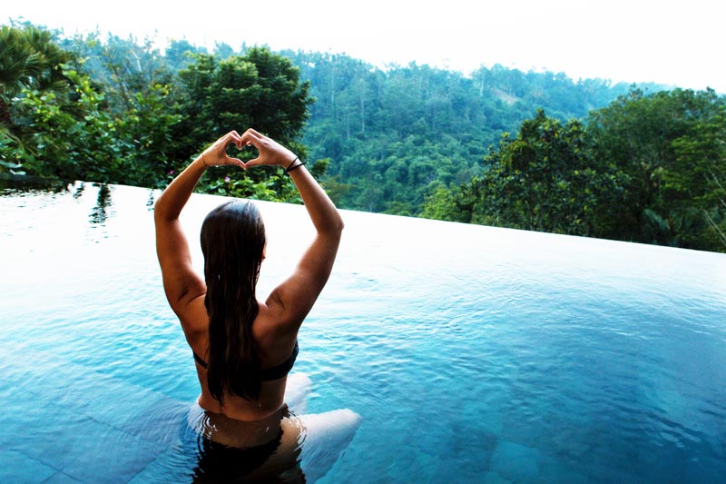 Mujer en una piscina en plena naturaleza
